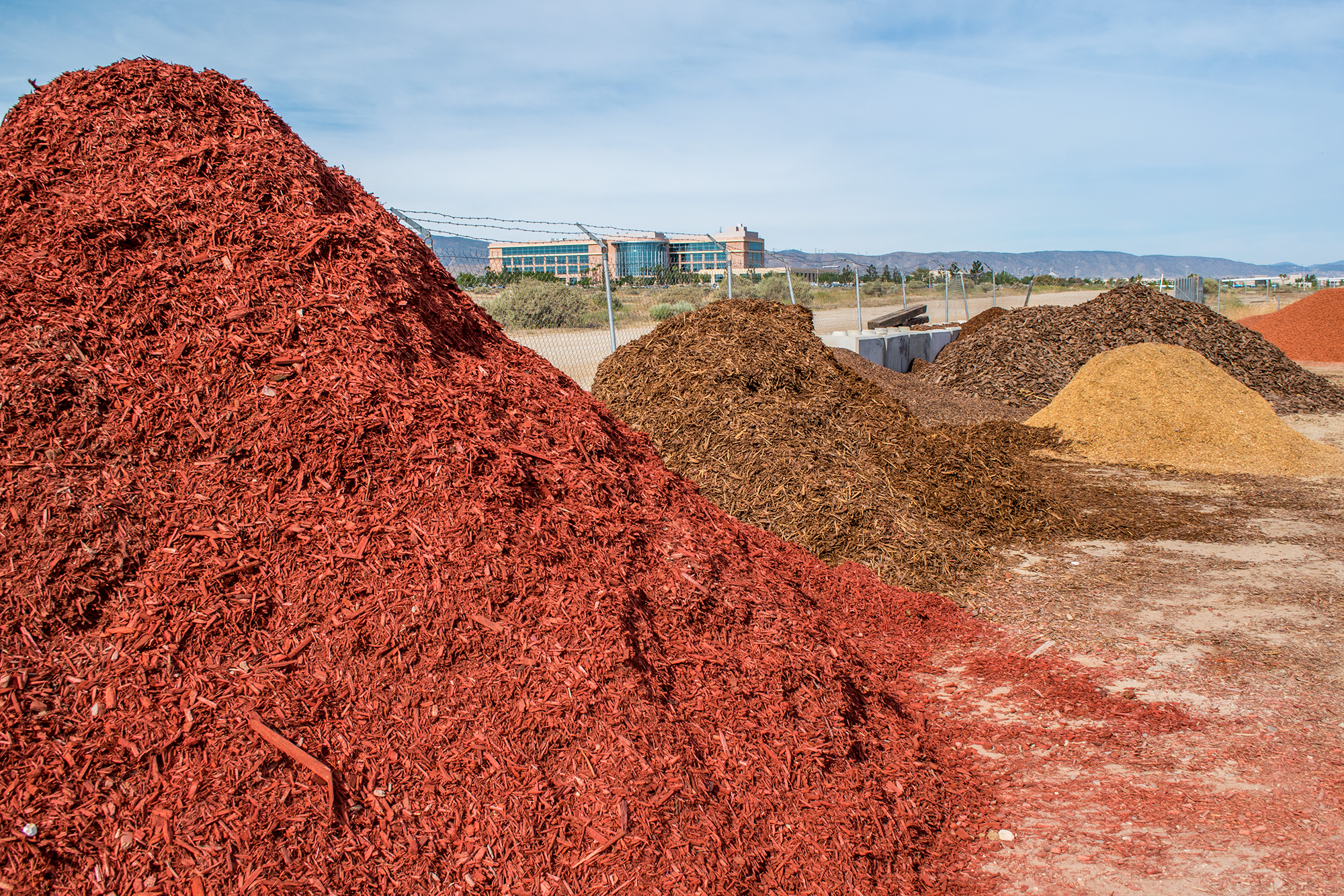 Red mulch and decorative rock piles at Paradise Landscape Supply yard